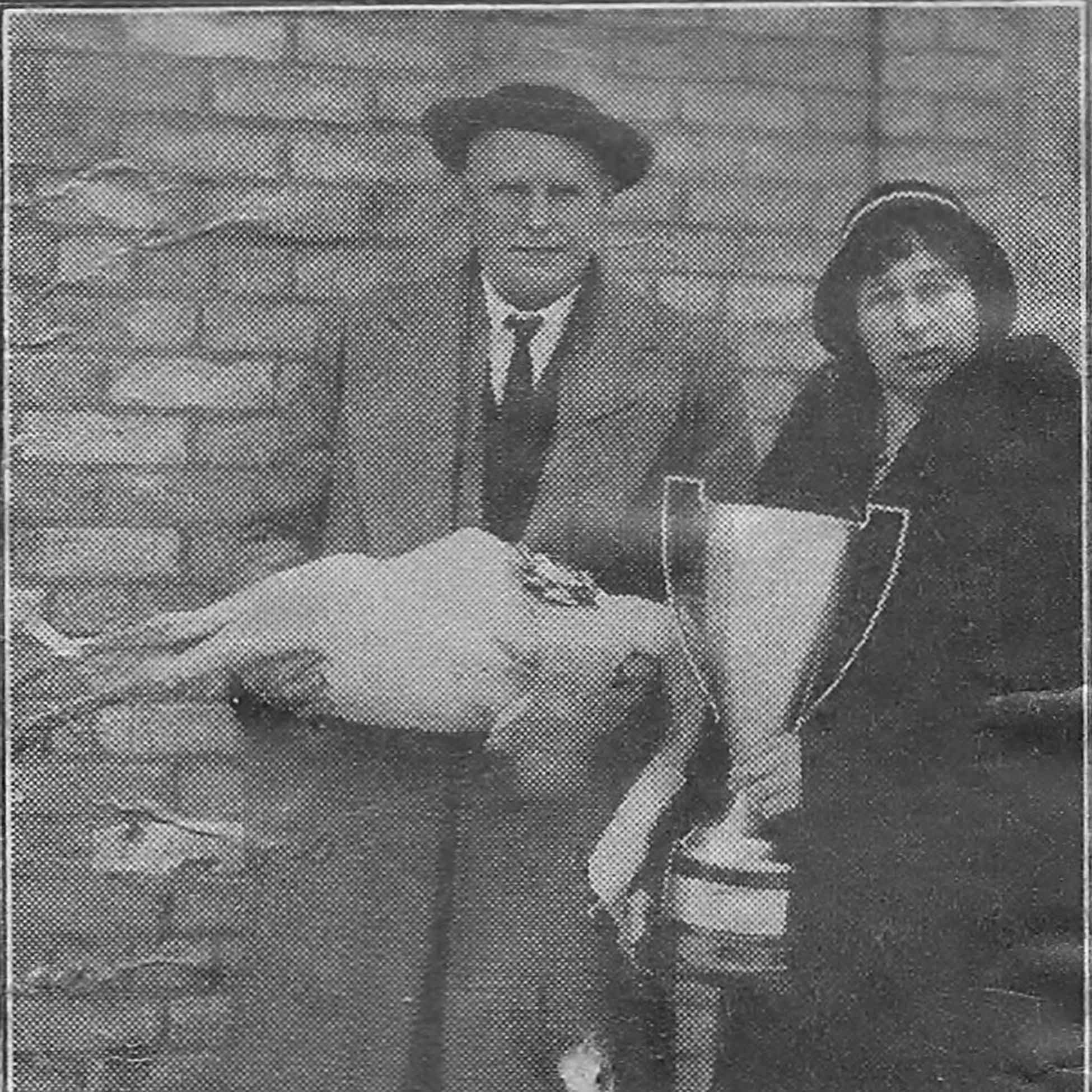 An old black and white photo of a man holding his prize winning turkey